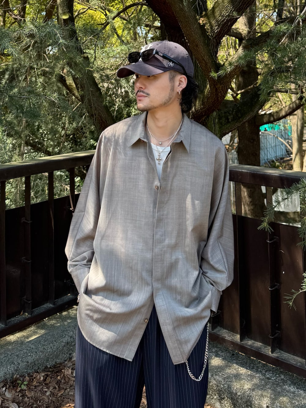 グレー系のシャツ/ブラウス、ブルー系のスラックス、シルバー系のウォレットチェーンを着用したメンズの春コーディネートの4枚目の写真