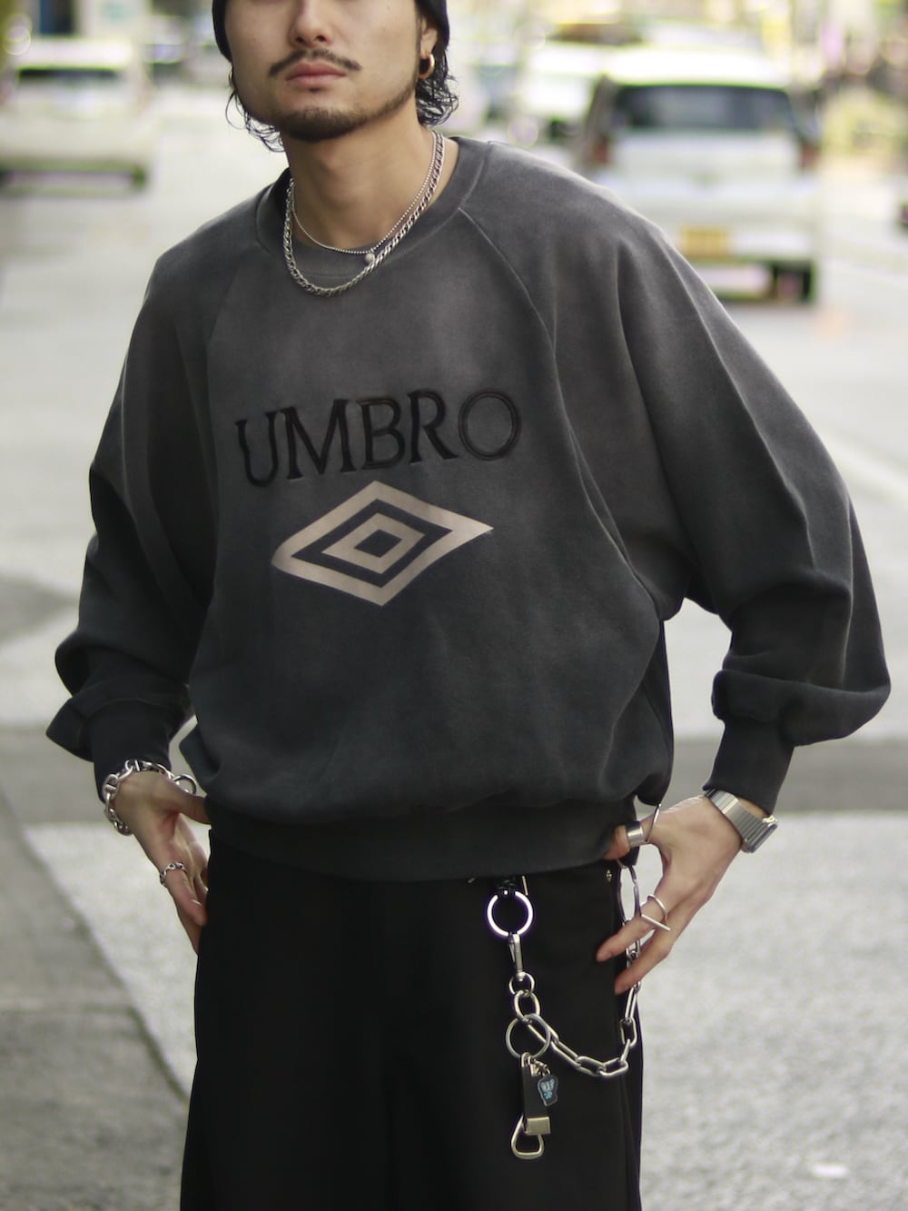 グレー系のスウェット、ブラック系のスラックス、ブラック系のキーホルダーを着用したメンズの冬コーディネートの3枚目の写真