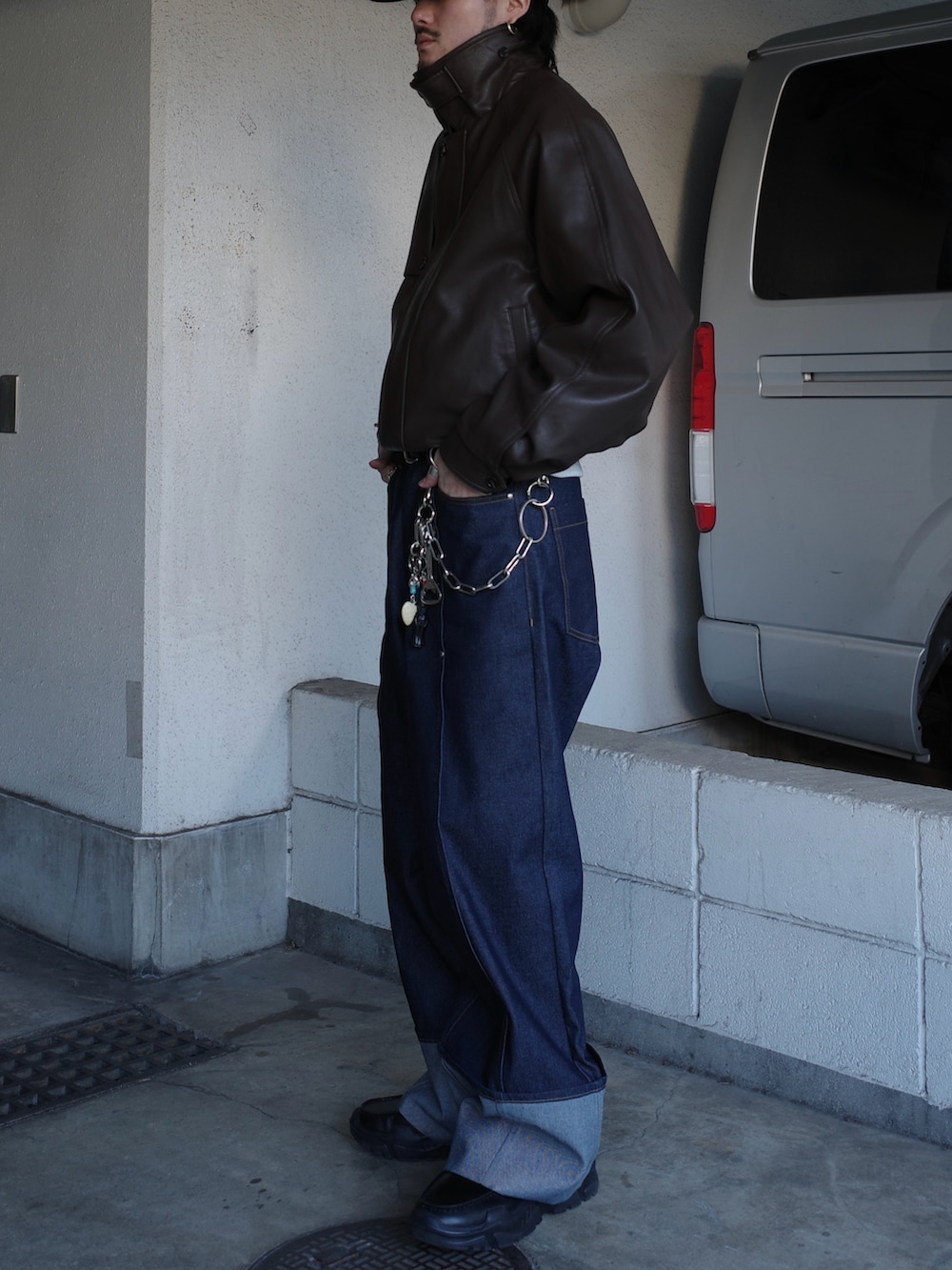 ブラウン系のブルゾン、ブルー系のデニムパンツを着用したメンズの冬コーディネートの5枚目の写真