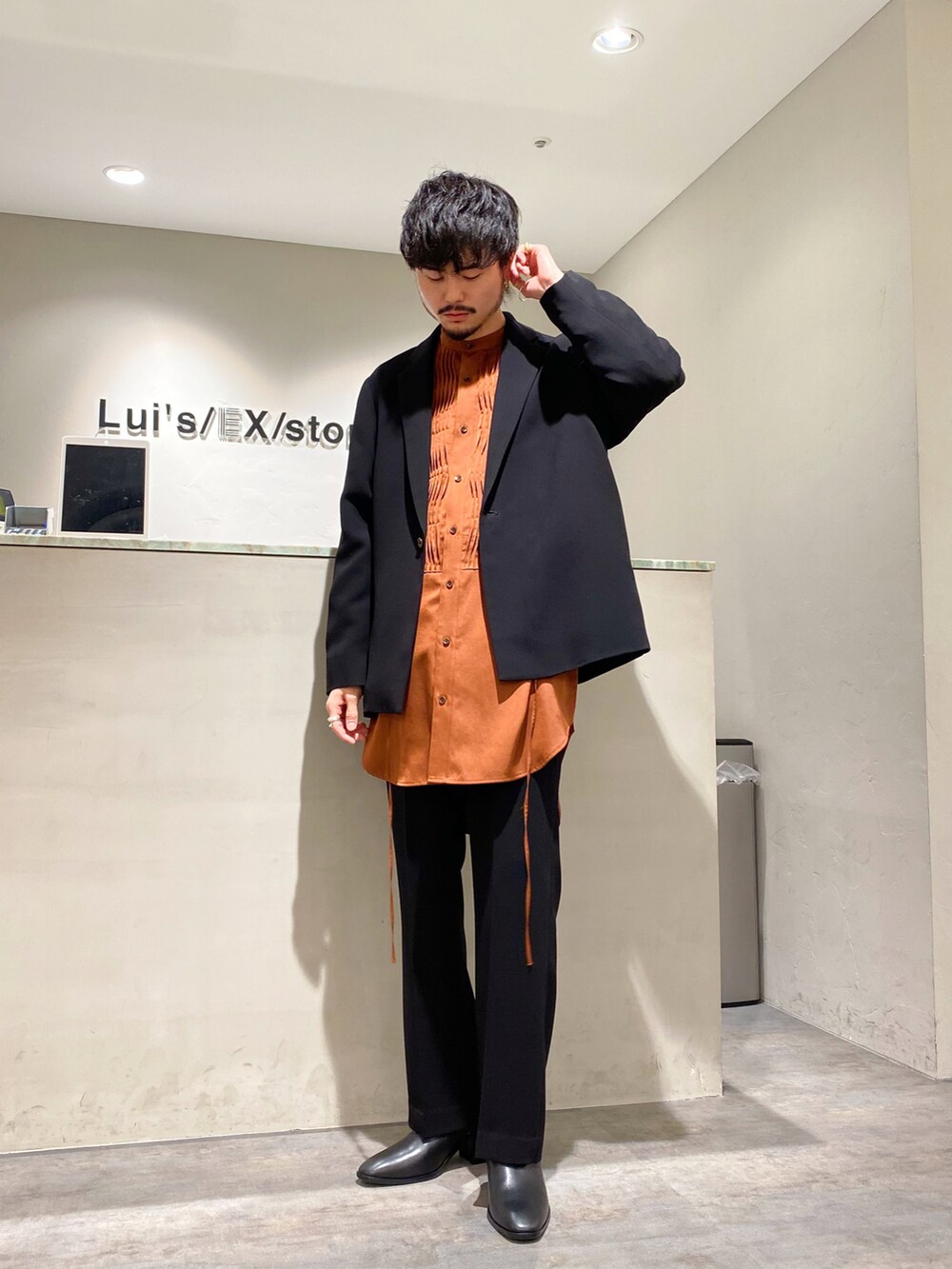 ブラウン系のシャツ/ブラウス、ブラック系のテーラードジャケット、ブラック系のスラックスを着用したメンズの春コーディネートの2枚目の写真