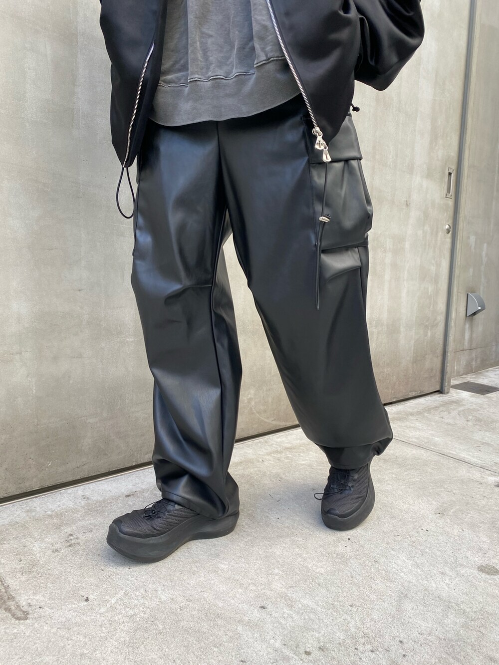 ブラック系のブルゾン、グレー系のスウェット、ブラック系のカーゴパンツを着用したメンズの冬コーディネートの4枚目の写真