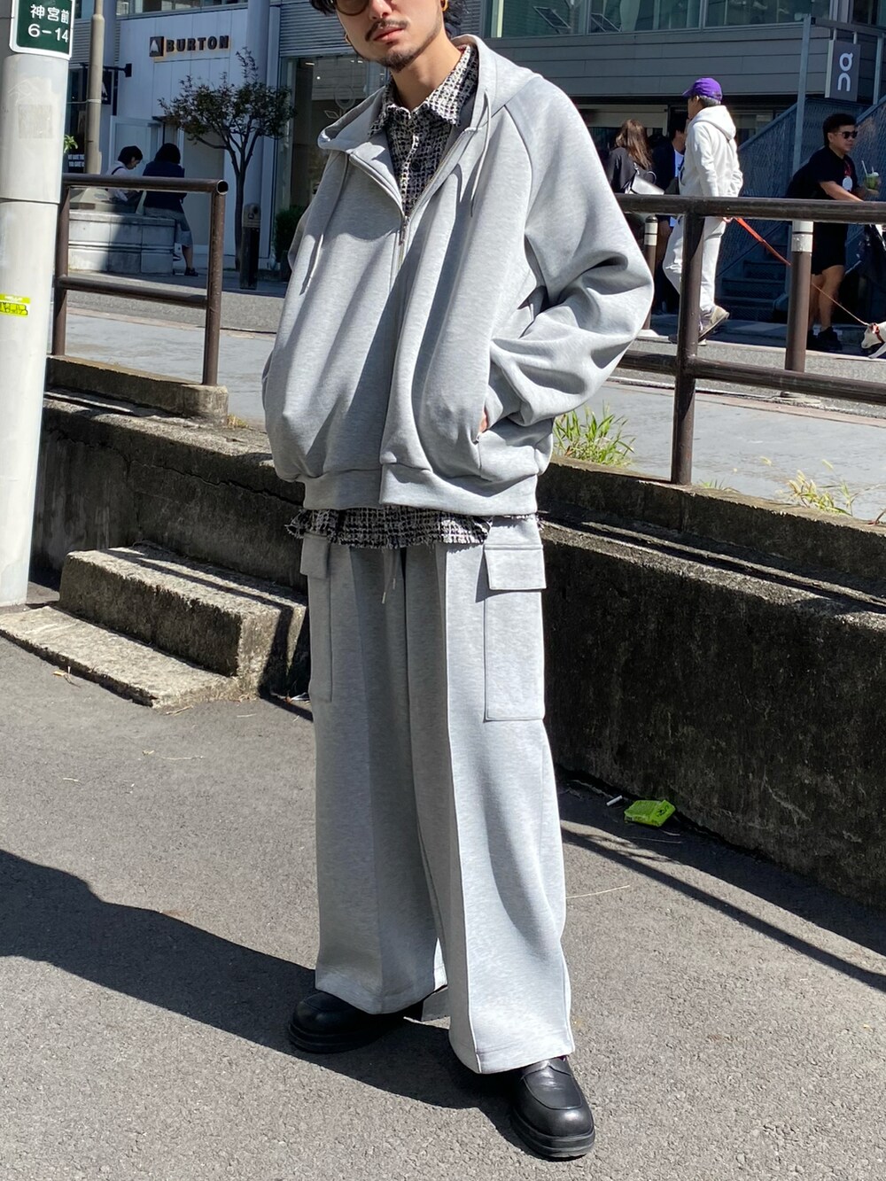 グレー系のパーカー、グレー系のカーゴパンツ、ブラック系のブーツを着用したメンズの秋コーディネートの3枚目の写真