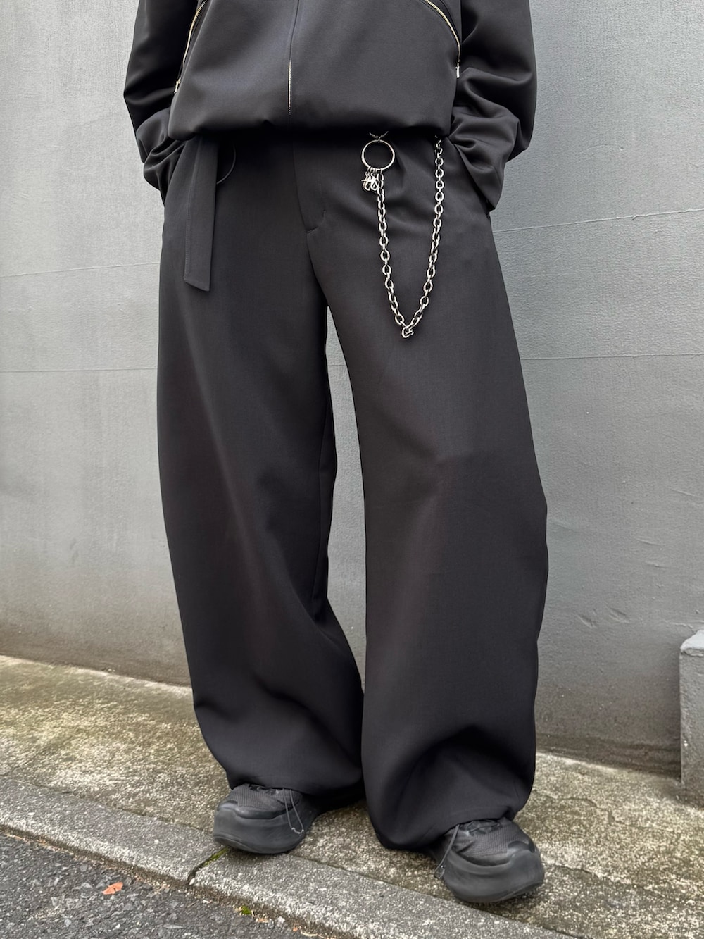 ブラック系のブルゾン、ブラック系のスラックス、ブラック系のウォレットチェーンを着用したメンズの春コーディネートの5枚目の写真