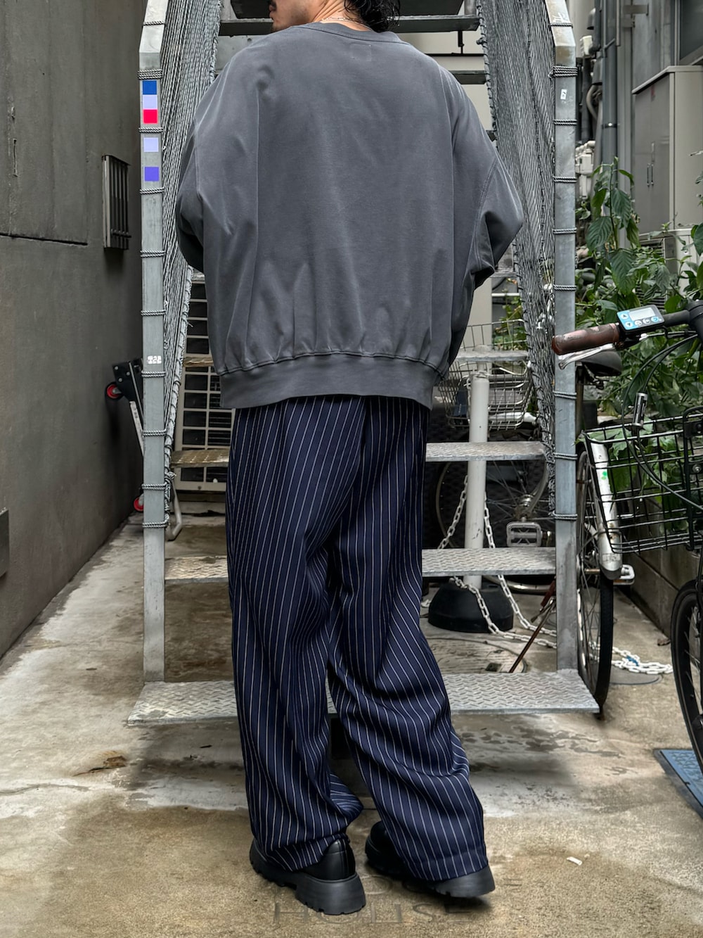 グレー系のTシャツ/カットソー、ブルー系のその他パンツ、ブラック系のブーツを着用したメンズの秋コーディネートの3枚目の写真