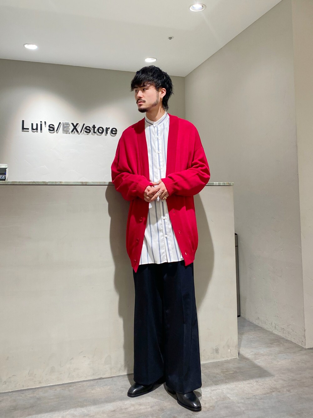 レッド系のカーディガン/ボレロ、ホワイト系のシャツ/ブラウス、ブラック系のスラックスを着用したメンズの春コーディネートの2枚目の写真