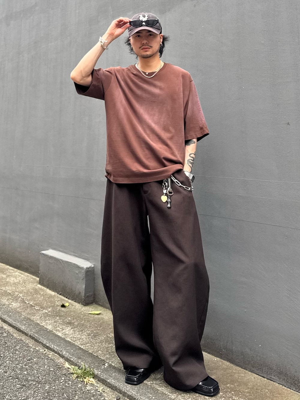グレー系のスラックス、ブラウン系のTシャツ/カットソーを着用したメンズの夏コーディネートの2枚目の写真