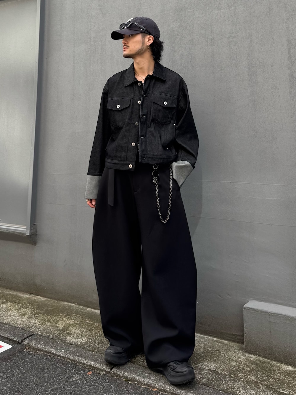 ブラック系のデニムジャケット、ブラック系のスラックス、ブラック系のウォレットチェーンを着用したメンズの春コーディネートの4枚目の写真