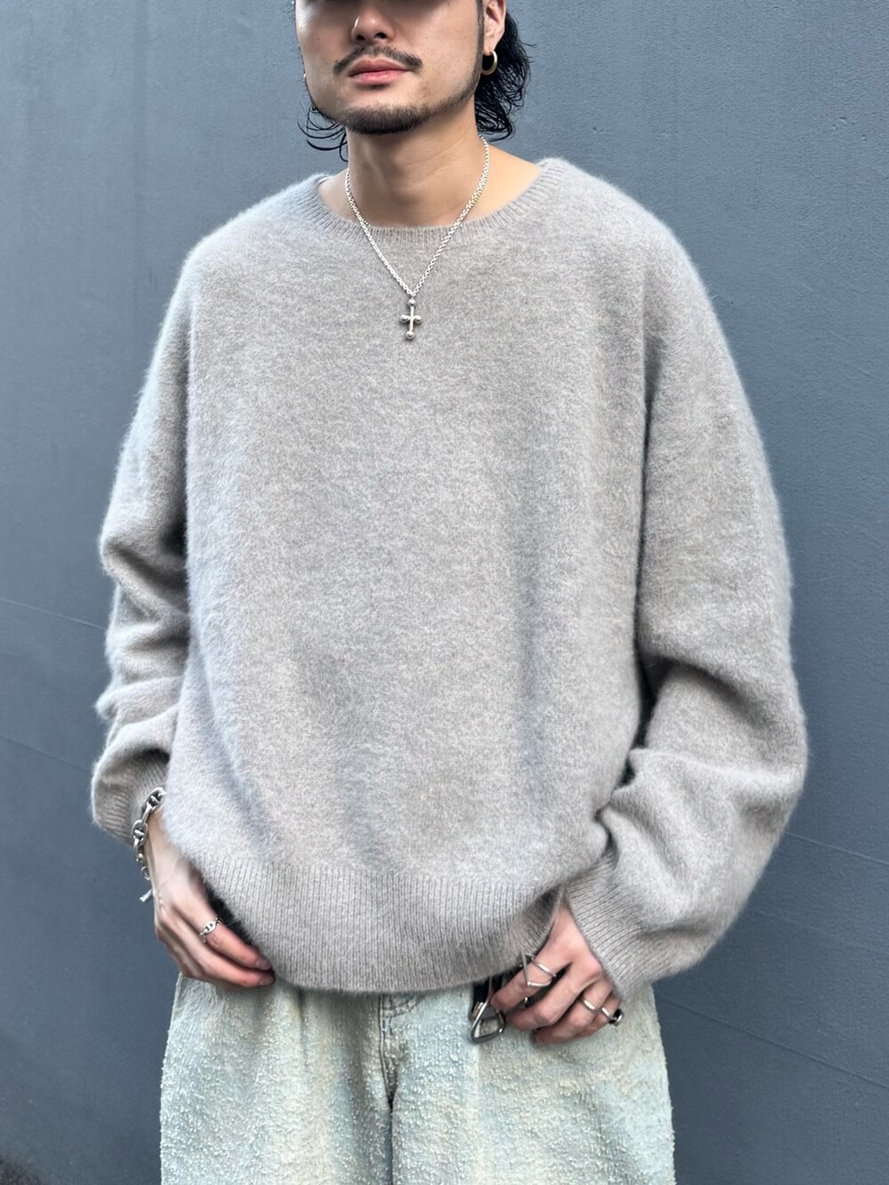 ブラウン系のニット/セーター、ブルー系のデニムパンツ、ブラック系のその他シューズを着用したメンズの秋コーディネートの5枚目の写真