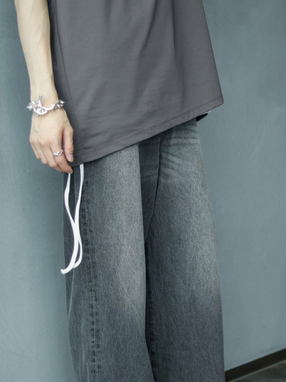 グレー系のTシャツ/カットソー、ホワイト系のタンクトップ、ブラック系のデニムパンツを着用したメンズの夏コーディネートの5枚目の写真