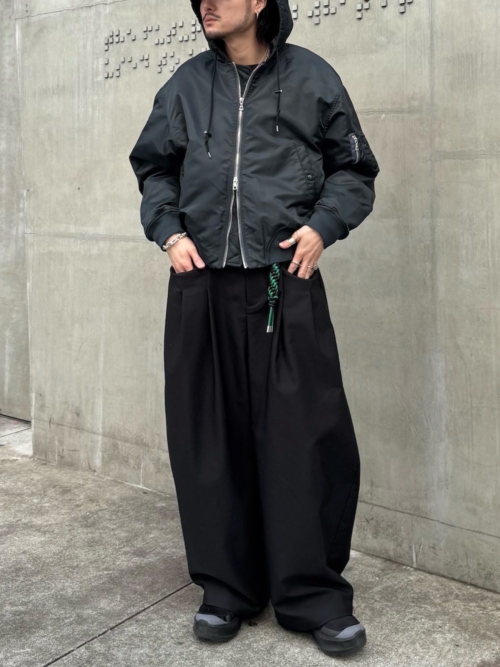 グリーン系のブルゾン、ブラック系のその他パンツ、ブラック系のキーホルダーを着用したメンズの冬コーディネートの4枚目の写真