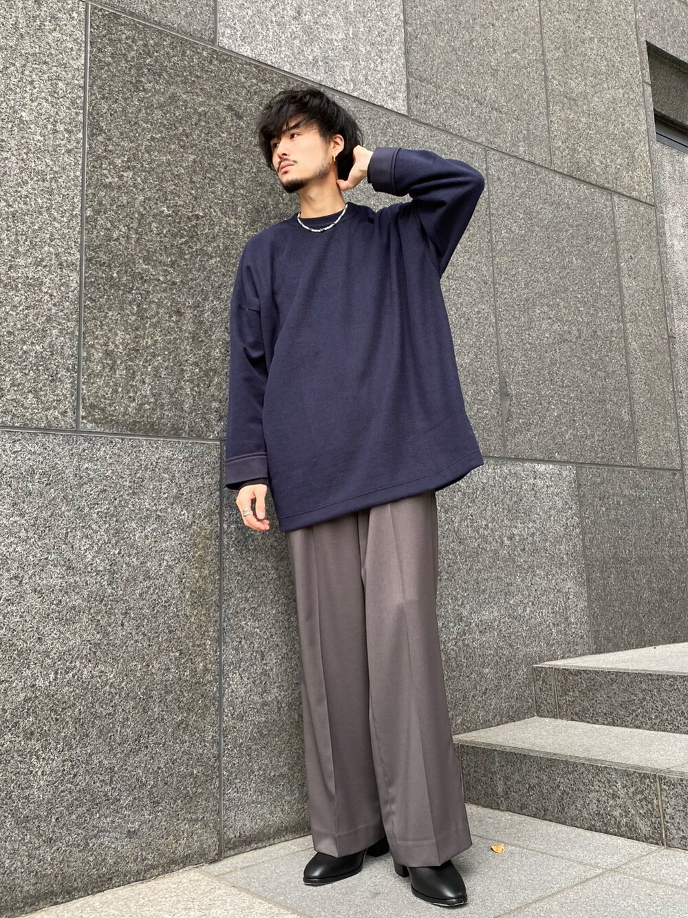 ブルー系のTシャツ/カットソー、グレー系のスラックス、ブラック系のドレスシューズを着用したメンズの冬コーディネートの3枚目の写真