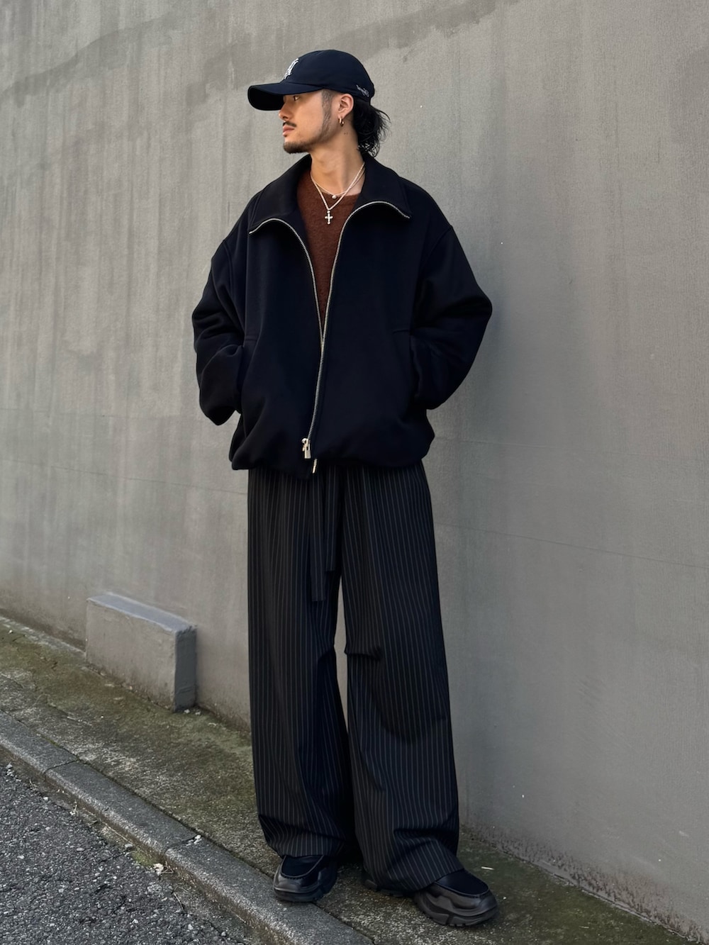 ブラウン系のニット/セーター、ブラック系のその他パンツ、ブラック系のローファーを着用したメンズの秋コーディネートの2枚目の写真