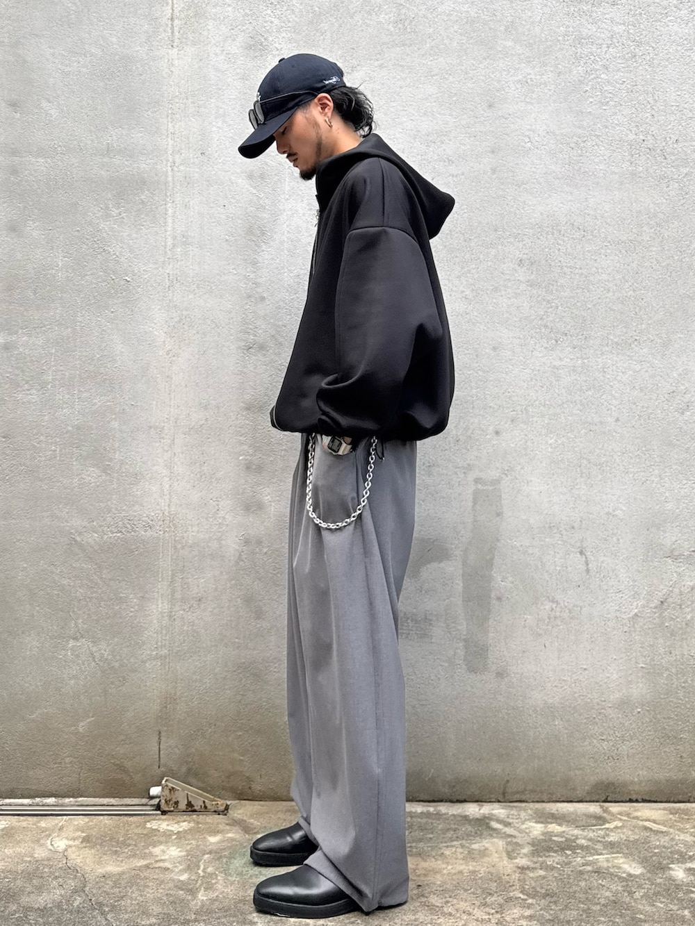 ブラック系のパーカー、グレー系のスラックス、シルバー系のウォレットチェーンを着用したメンズの秋コーディネートの3枚目の写真