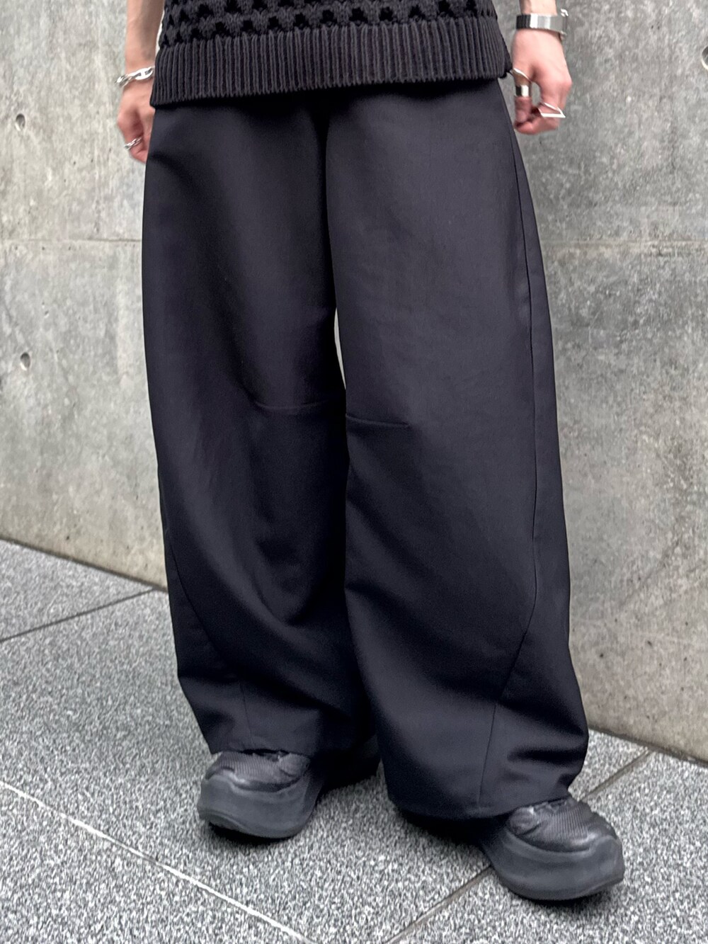 ブラック系のニット/セーター、ブラック系のスラックスを着用したメンズの春コーディネートの4枚目の写真