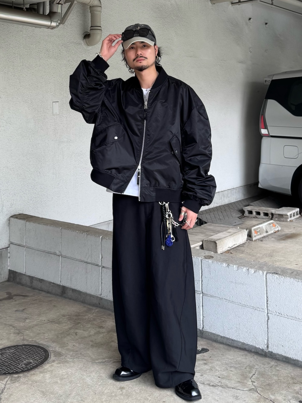 ブラック系のMA-1、ブラック系のスラックスを着用したメンズの秋コーディネートの2枚目の写真