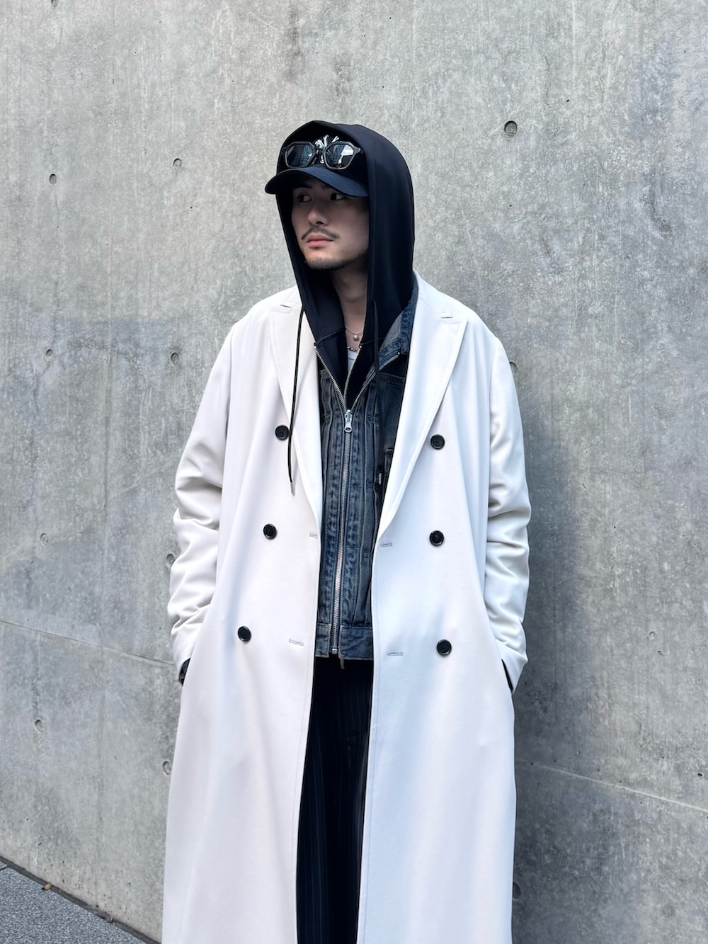 グレー系のチェスターコート、ブルー系のデニムジャケット、ブラック系のパーカーを着用したメンズの冬コーディネートの7枚目の写真