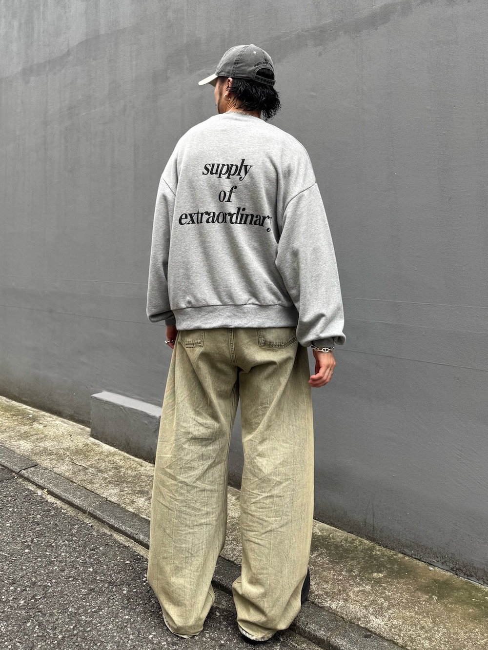 グレー系のTシャツ/カットソー、グリーン系のデニムパンツを着用したメンズの夏コーディネートの3枚目の写真