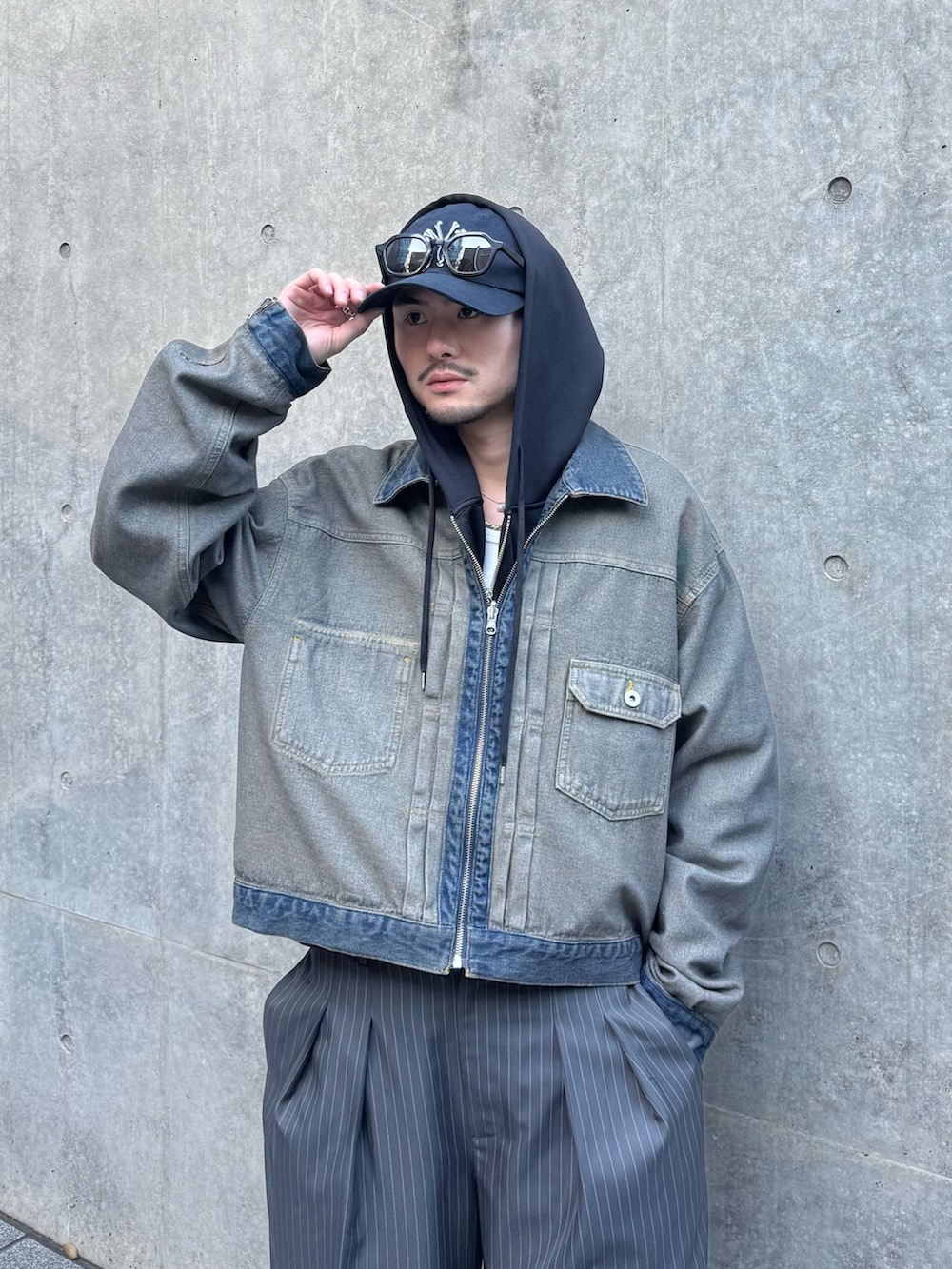 ブラック系のパーカー、ブルー系のデニムジャケット、グレー系のスラックスを着用したメンズの冬コーディネートの3枚目の写真