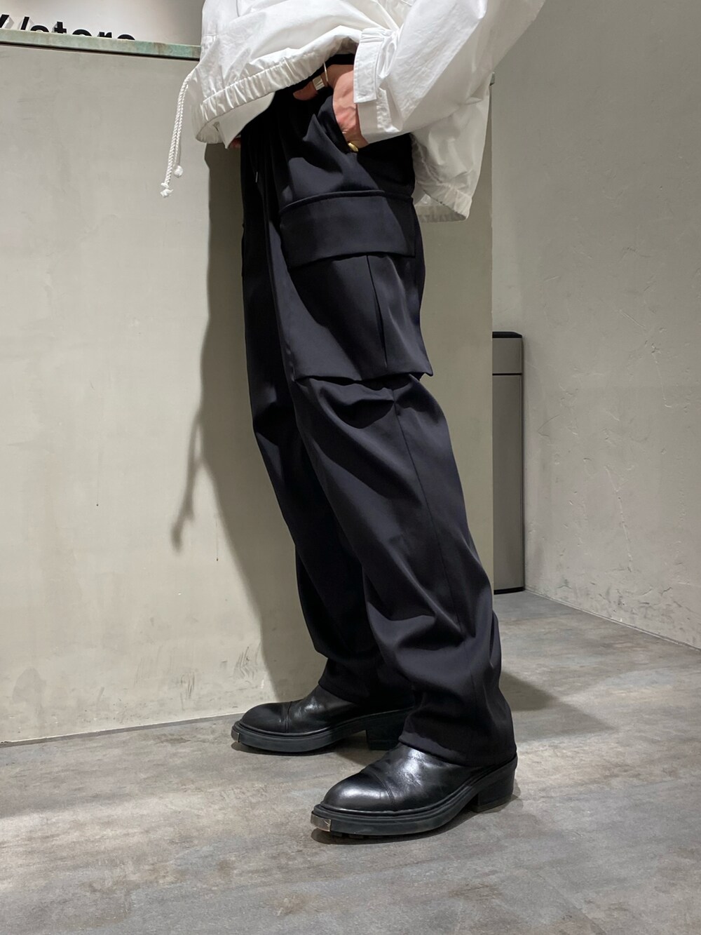 ホワイト系のマウンテンパーカー、ブラック系のカーゴパンツを着用したメンズの春コーディネートの4枚目の写真