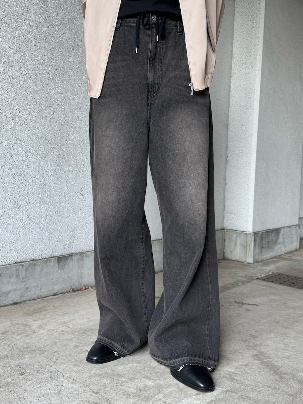 ブラック系のTシャツ/カットソー、ベージュ系のブルゾン、ブラック系のデニムパンツを着用したメンズの春コーディネートの5枚目の写真