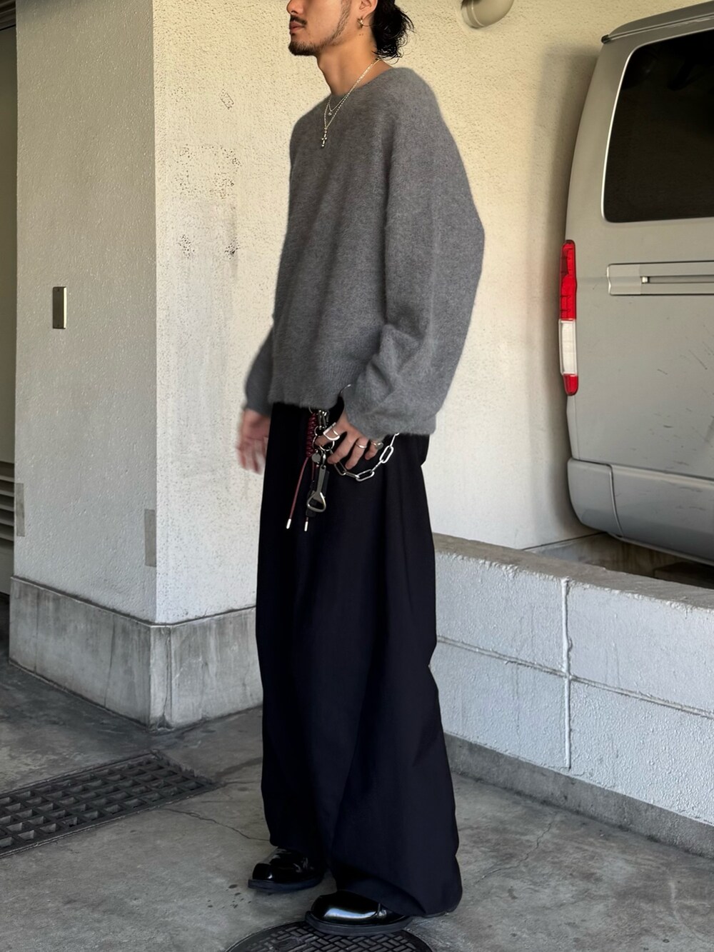 グレー系のニット/セーター、ブラック系のスラックスを着用したメンズの秋コーディネートの3枚目の写真