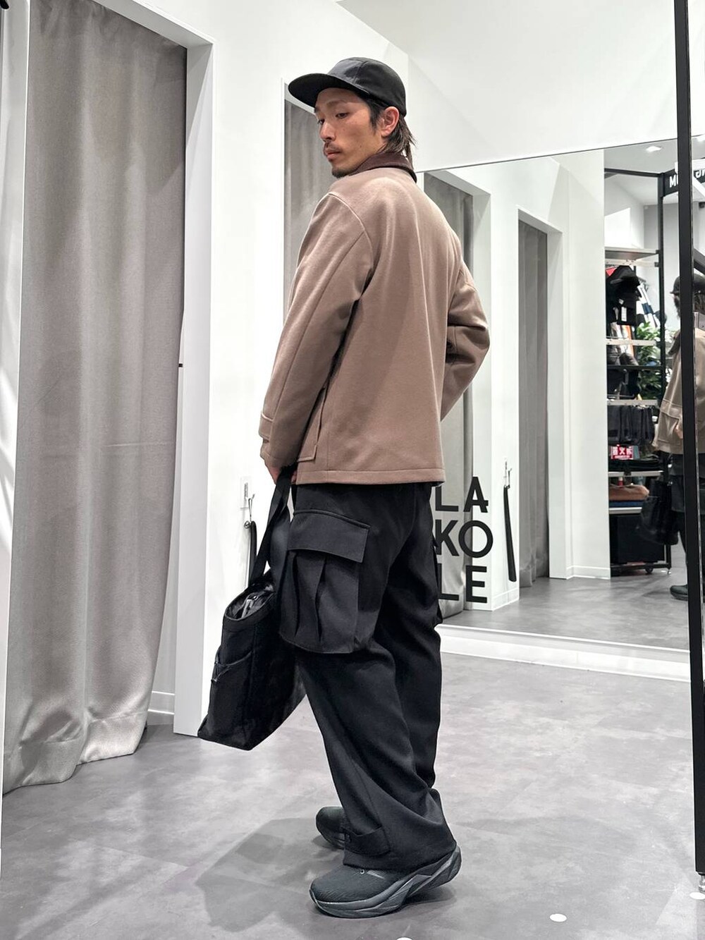 ブラック系のスニーカー、ベージュ系のブルゾン、ブラック系のトートバッグを着用したメンズの冬コーディネートの5枚目の写真