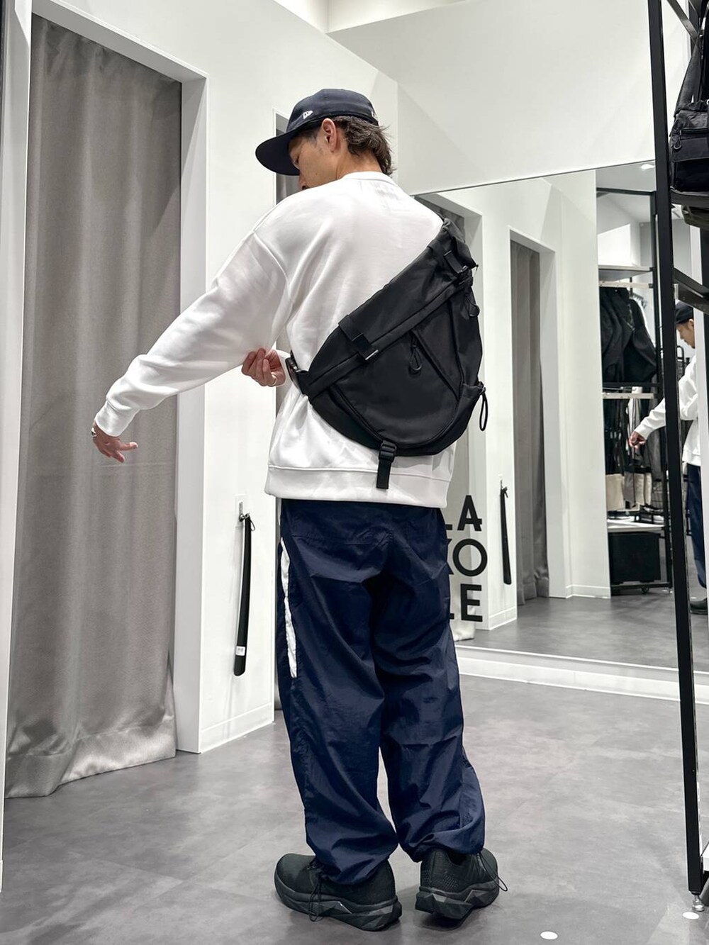 ブラック系のスニーカー、ブルー系のその他パンツ、ブラック系のショルダーバッグを着用したメンズの秋コーディネートの5枚目の写真