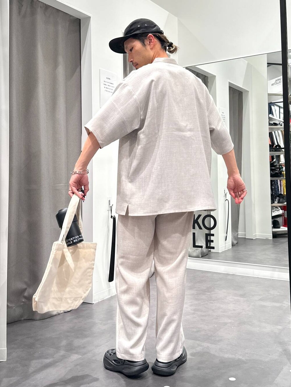 ブラック系のサンダル、ホワイト系のシャツ/ブラウス、その他のエコバッグ/サブバッグを着用したメンズの春コーディネートの4枚目の写真