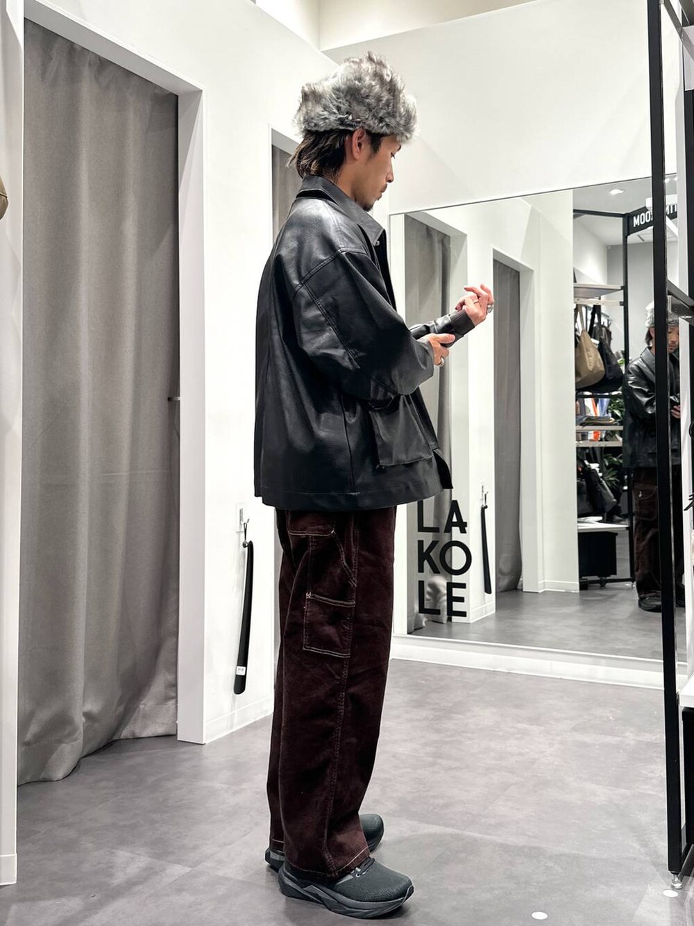 ブラック系のスニーカー、グレー系のニット/セーター、ブラック系のブルゾンを着用したメンズの秋コーディネートの5枚目の写真