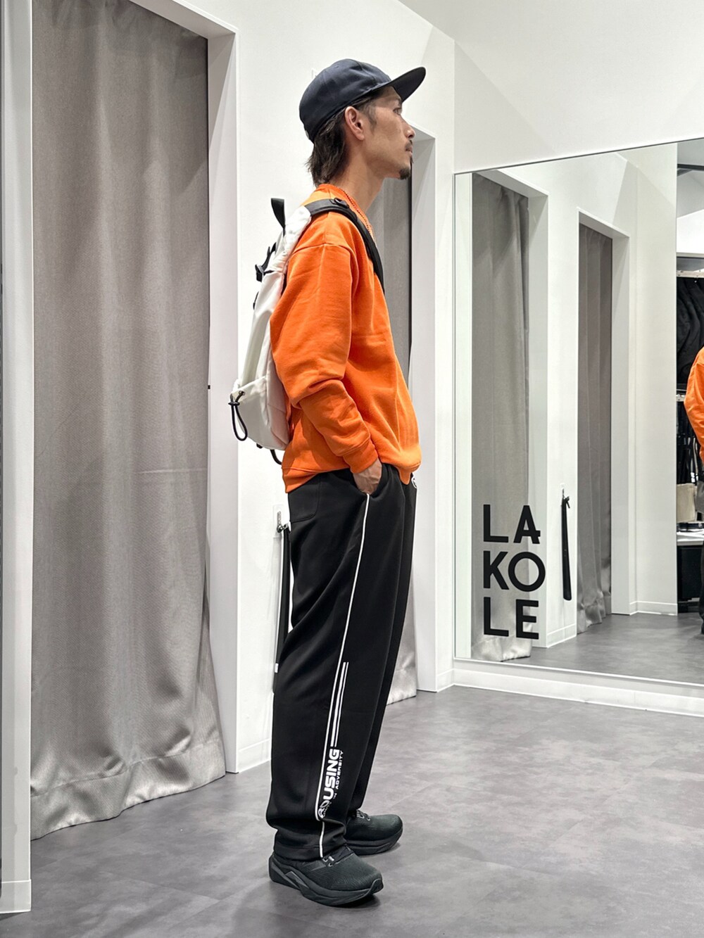 ブラック系のその他パンツ、ブラック系のスニーカー、オレンジ系のスウェットを着用したメンズの秋コーディネートの4枚目の写真