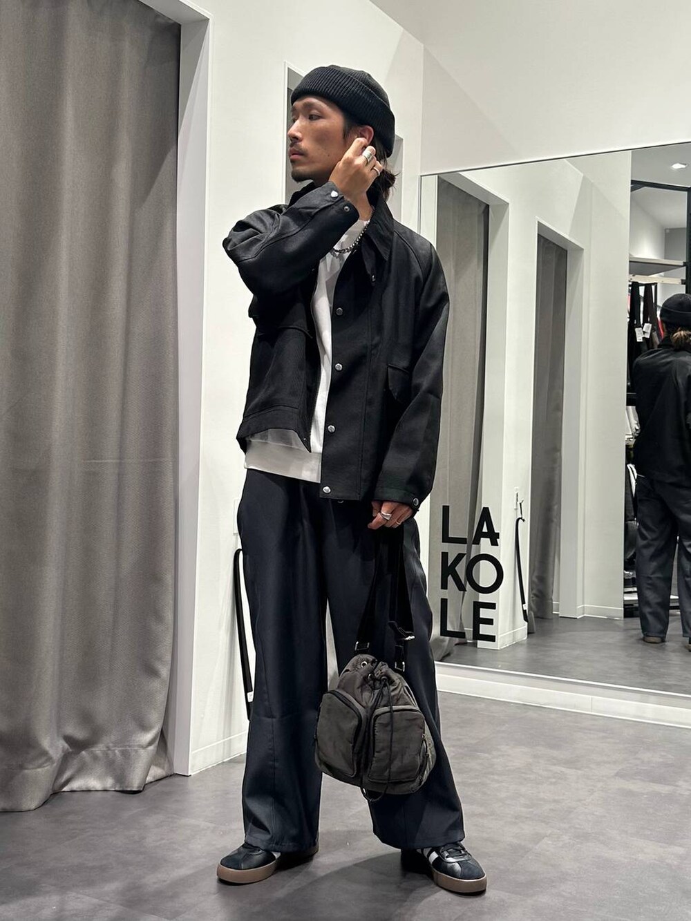 グレー系のその他パンツ、グレー系のショルダーバッグ、ブラック系のスニーカーを着用したメンズの秋コーディネートの5枚目の写真