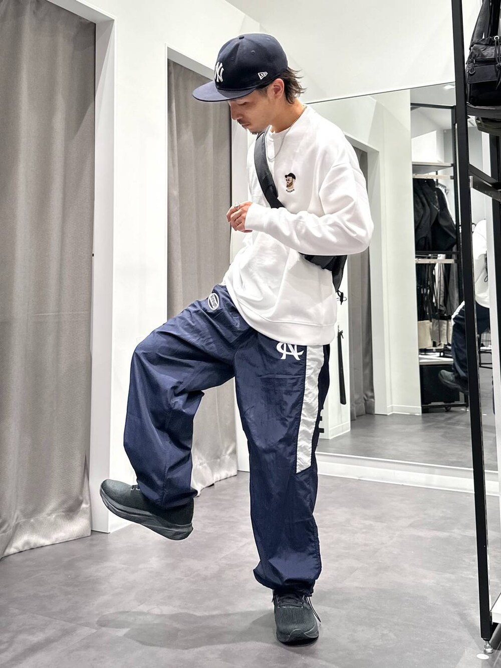 ブラック系のスニーカー、ブルー系のその他パンツ、ブラック系のショルダーバッグを着用したメンズの秋コーディネートの3枚目の写真