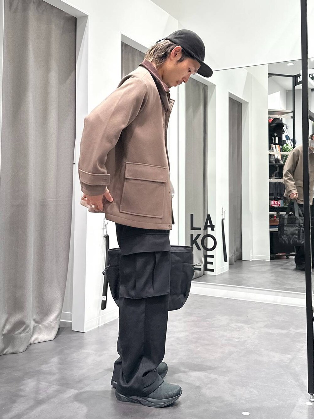 ブラック系のスニーカー、ベージュ系のブルゾン、ブラック系のトートバッグを着用したメンズの冬コーディネートの3枚目の写真