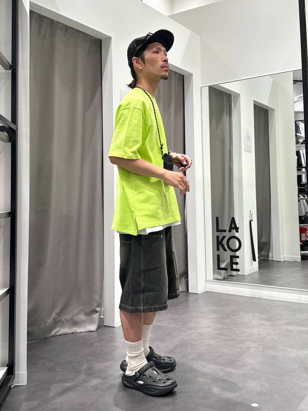 ブラック系のデニムパンツ、ホワイト系のTシャツ/カットソー、ブラック系のサンダルを着用したメンズの春コーディネートの5枚目の写真