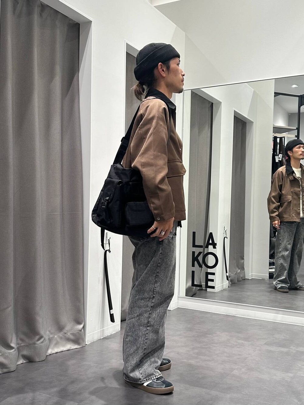 ブラック系のショルダーバッグ、ブラック系のスニーカー、ベージュ系のニット/セーターを着用したメンズの秋コーディネートの5枚目の写真