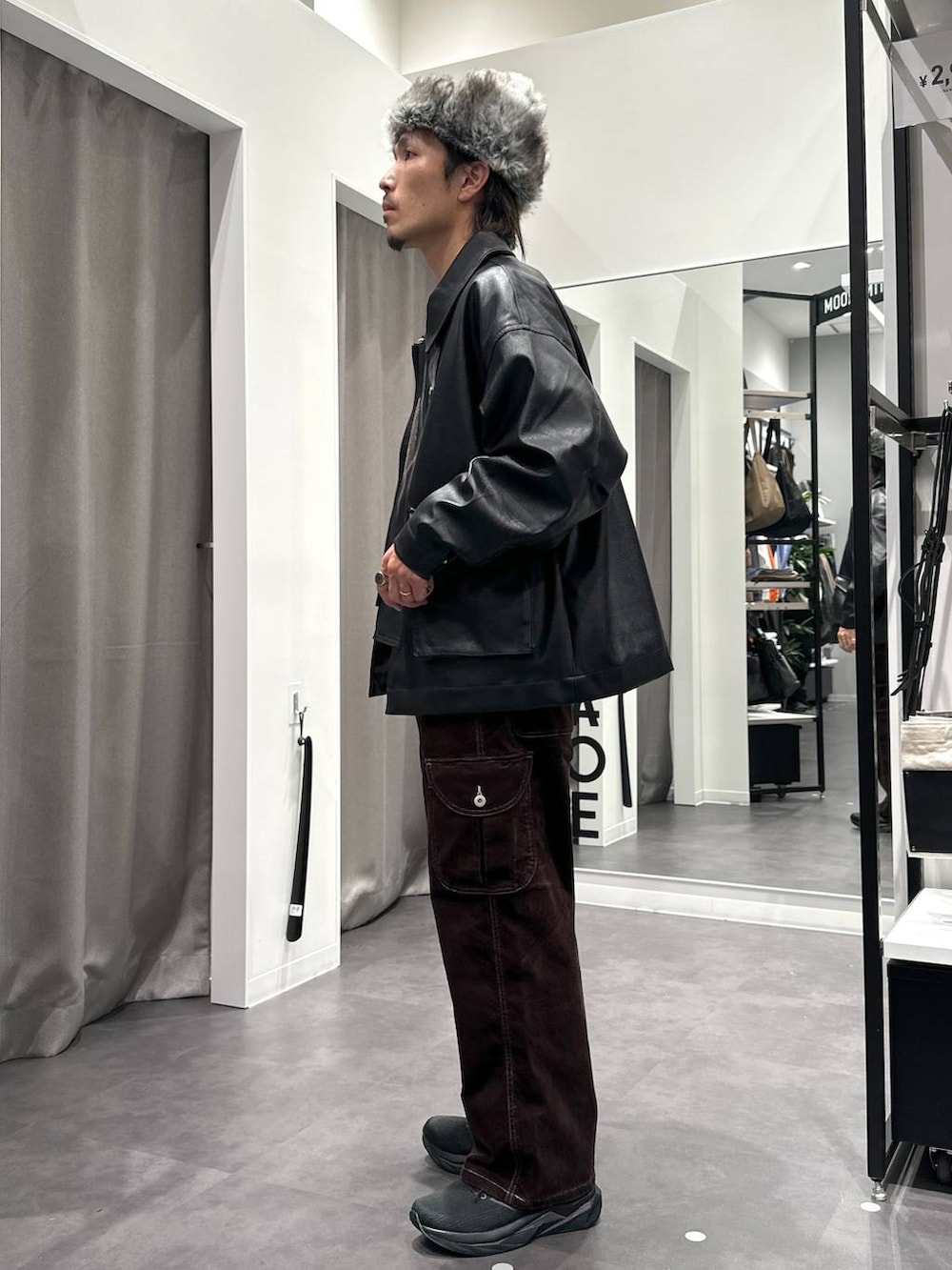 ブラック系のスニーカー、グレー系のニット/セーター、ブラック系のブルゾンを着用したメンズの秋コーディネートの3枚目の写真