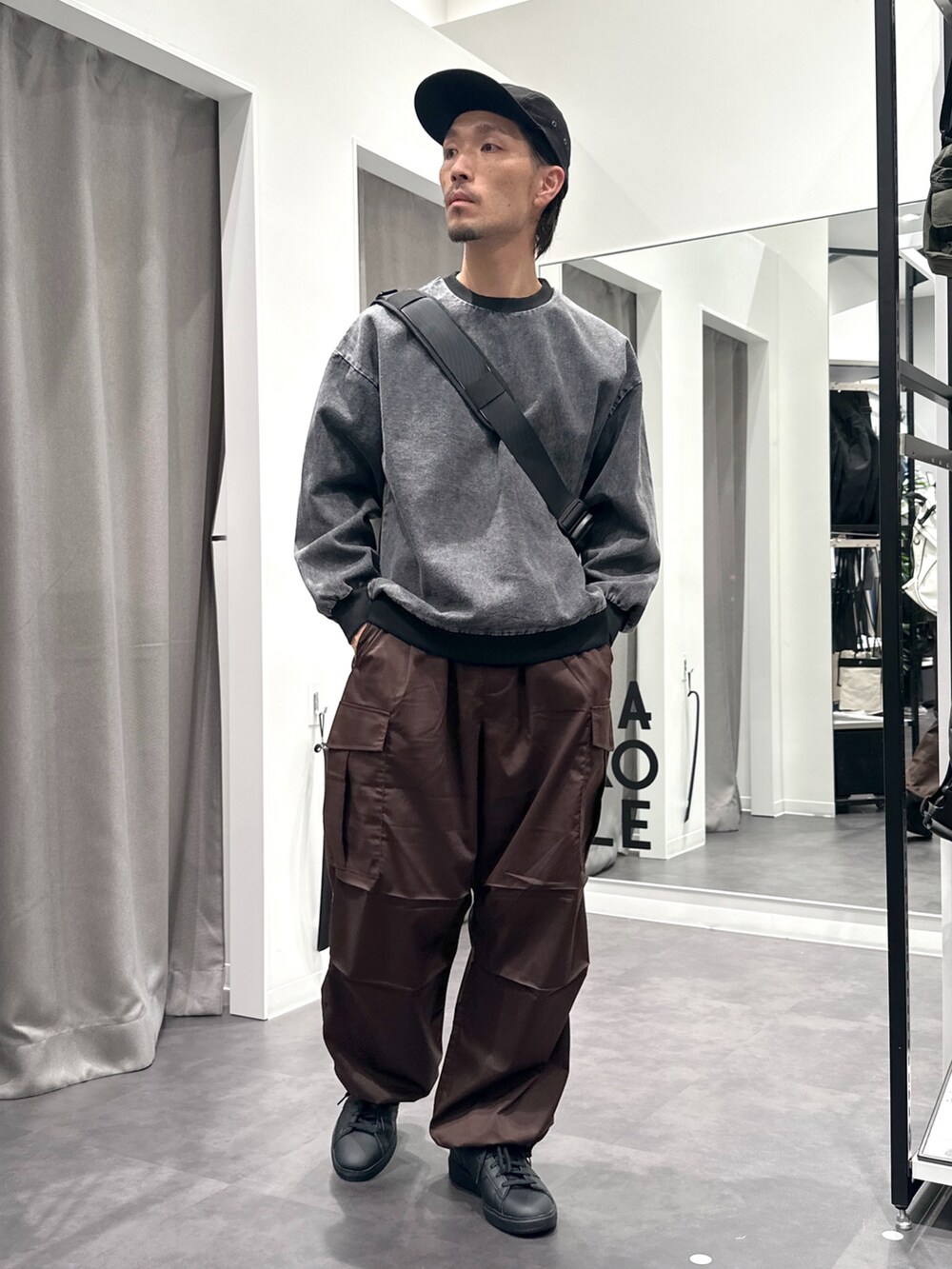 ブラック系のスニーカー、ブラウン系のカーゴパンツ、ブラック系のTシャツ/カットソーを着用したメンズの秋コーディネートの4枚目の写真