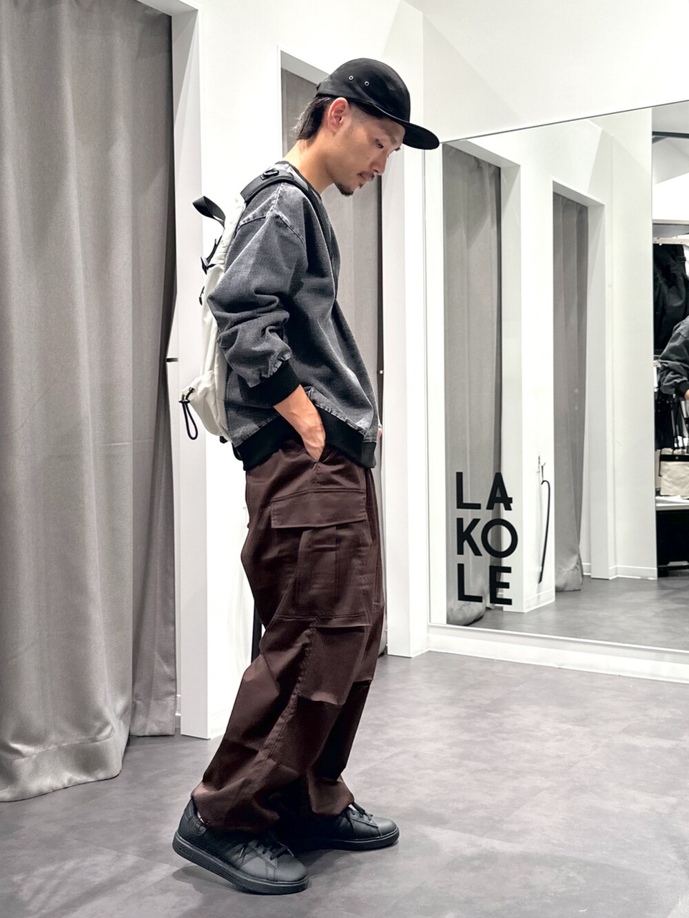 ブラック系のスニーカー、ブラウン系のカーゴパンツ、ブラック系のTシャツ/カットソーを着用したメンズの秋コーディネートの2枚目の写真