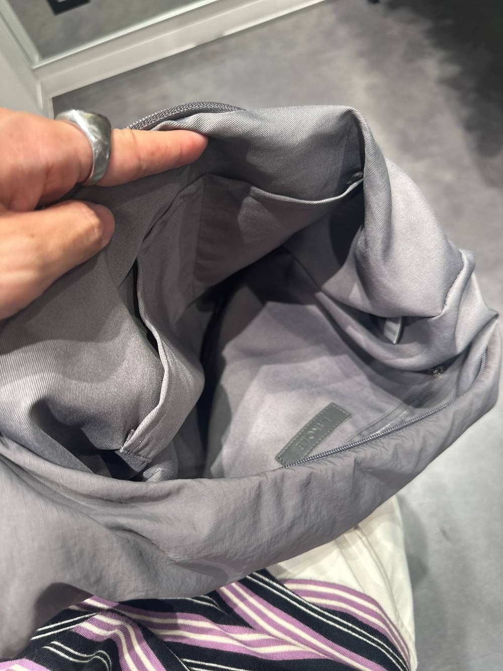 ブラック系のデニムパンツ、ベージュ系のTシャツ/カットソー、グレー系のショルダーバッグを着用したメンズの夏コーディネートの8枚目の写真