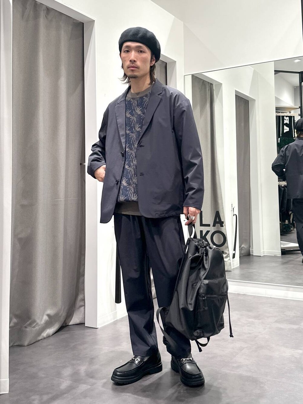 ブルー系のテーラードジャケット、ブラック系のローファー、ブルー系のニット/セーターを着用したメンズの冬コーディネートの5枚目の写真