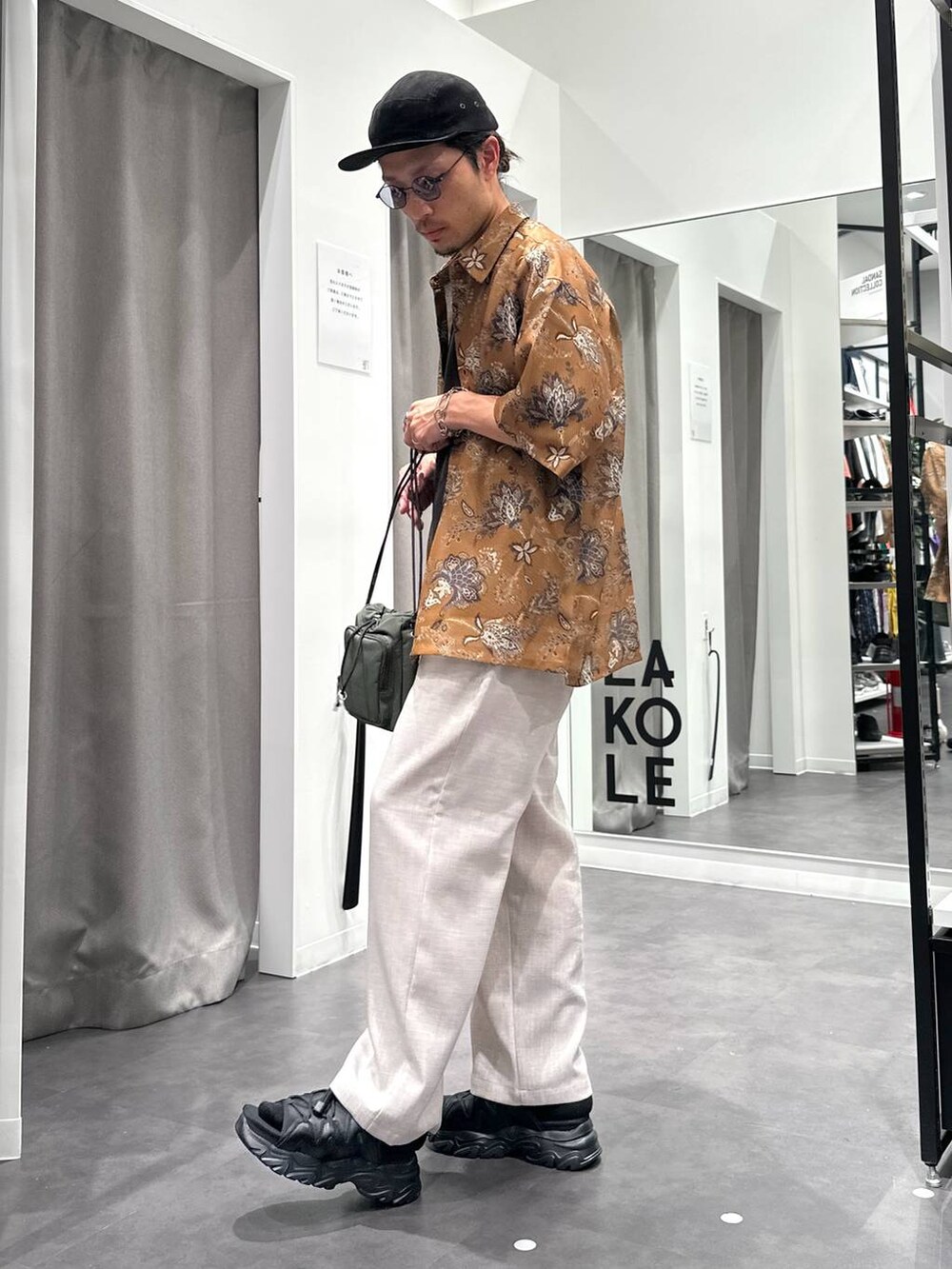 ブラック系のサンダル、ホワイト系のその他パンツ、グリーン系のショルダーバッグを着用したメンズの春コーディネートの3枚目の写真