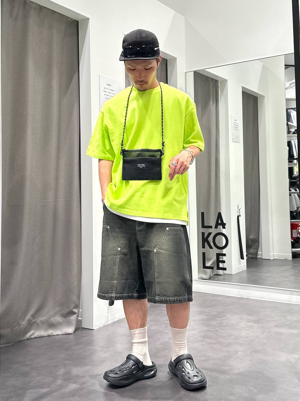 ブラック系のデニムパンツ、ホワイト系のTシャツ/カットソー、ブラック系のサンダルを着用したメンズの春コーディネートの6枚目の写真