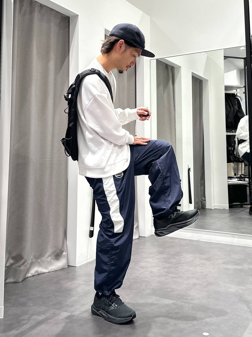 ブラック系のスニーカー、ブルー系のその他パンツ、ブラック系のショルダーバッグを着用したメンズの秋コーディネートの4枚目の写真