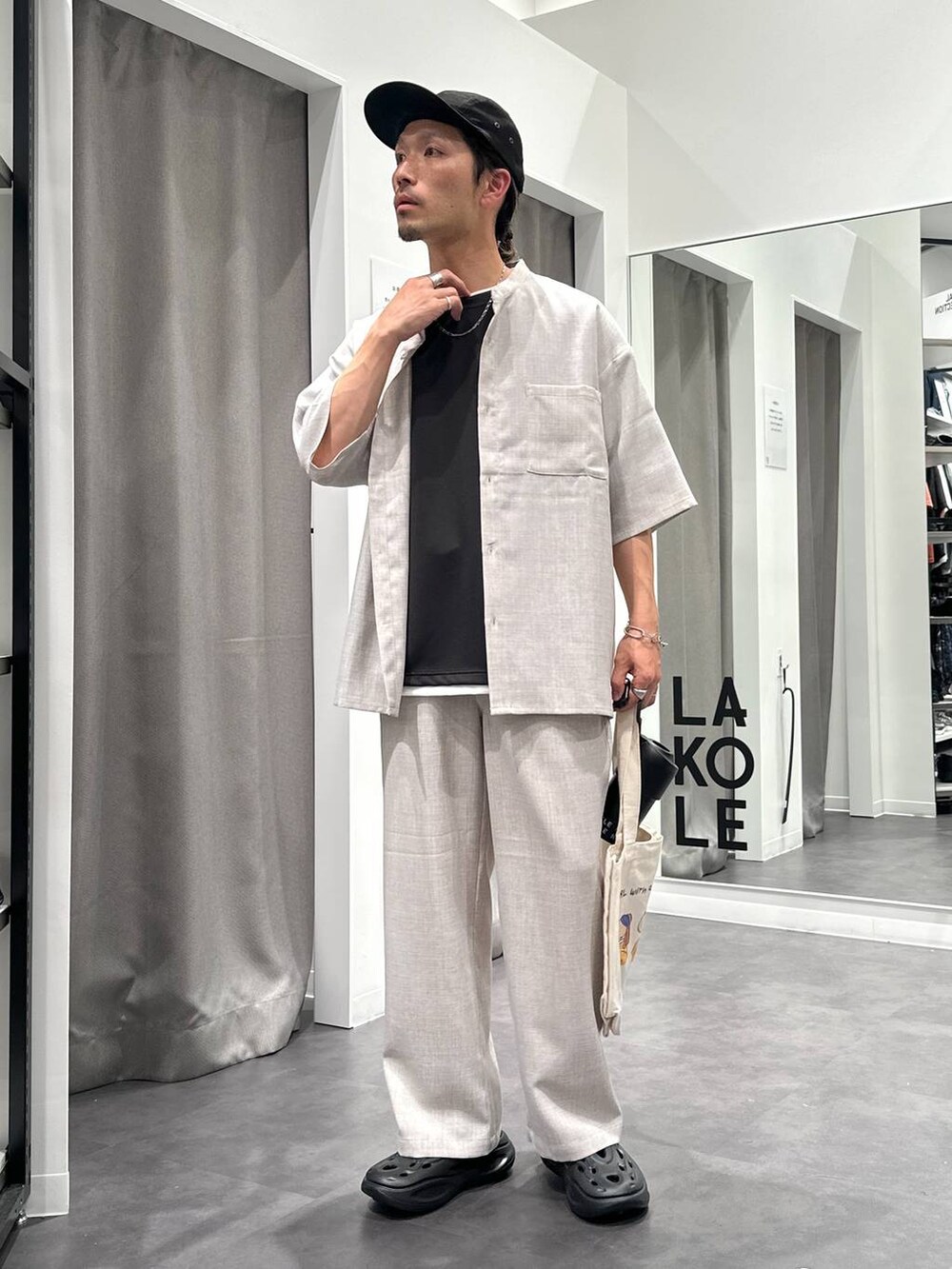 ブラック系のサンダル、ホワイト系のシャツ/ブラウス、その他のエコバッグ/サブバッグを着用したメンズの春コーディネートの3枚目の写真