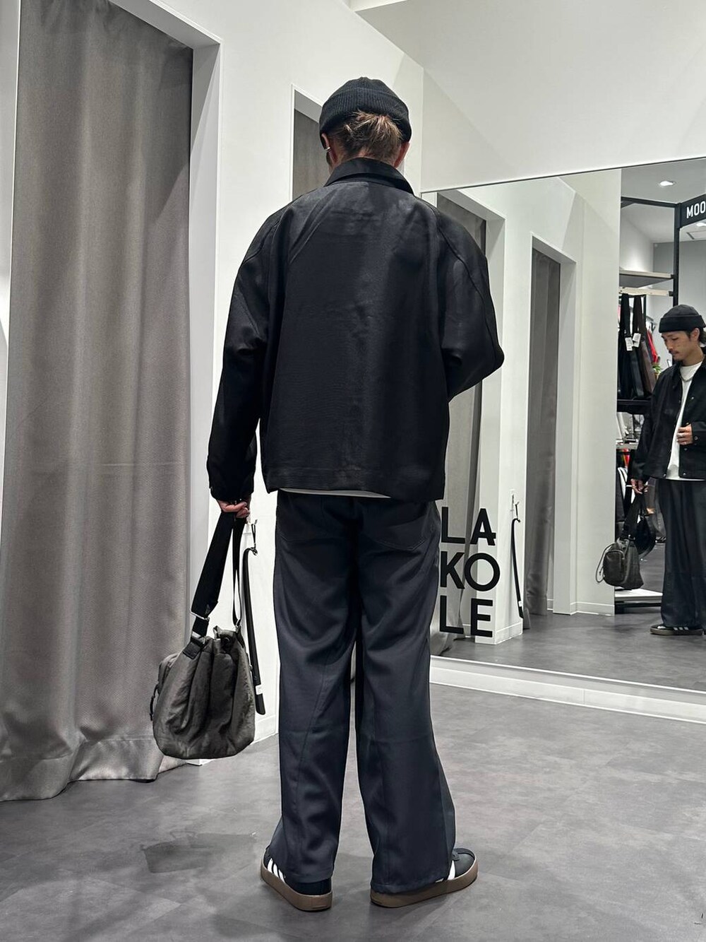 グレー系のその他パンツ、グレー系のショルダーバッグ、ブラック系のスニーカーを着用したメンズの秋コーディネートの3枚目の写真