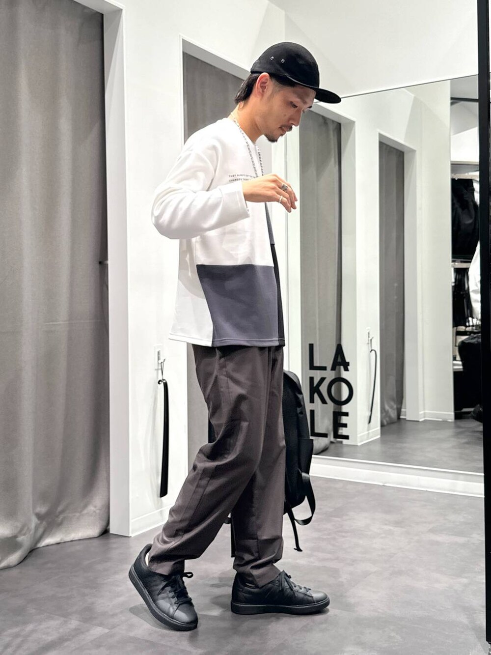 グレー系のその他パンツ、ブラック系のTシャツ/カットソー、ブラック系のバックパック/リュックを着用したメンズの秋コーディネートの4枚目の写真