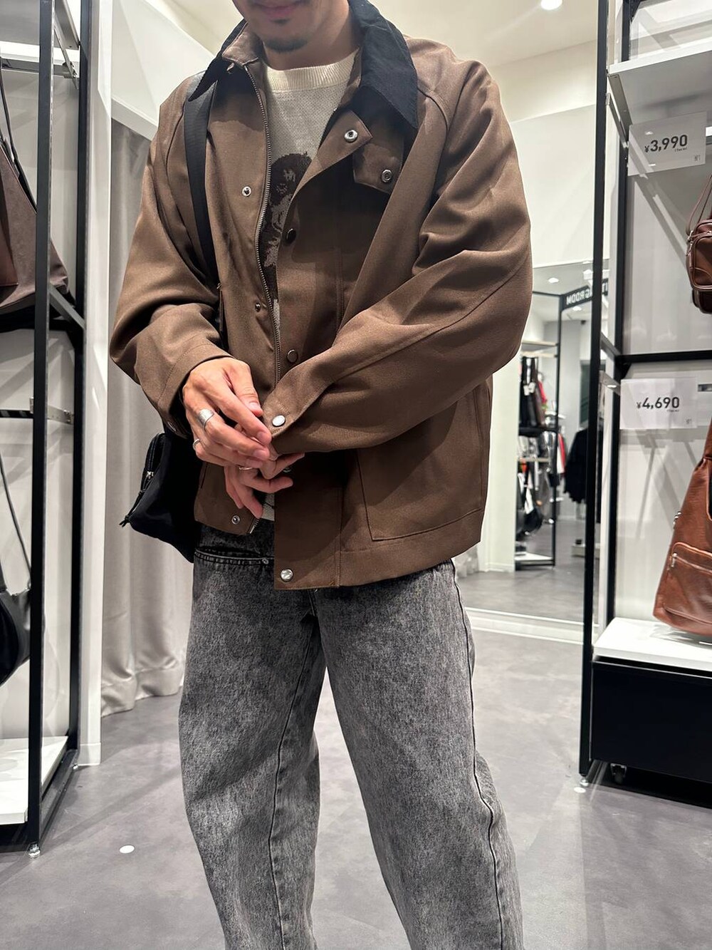 ブラック系のショルダーバッグ、ブラック系のスニーカー、ベージュ系のニット/セーターを着用したメンズの秋コーディネートの3枚目の写真