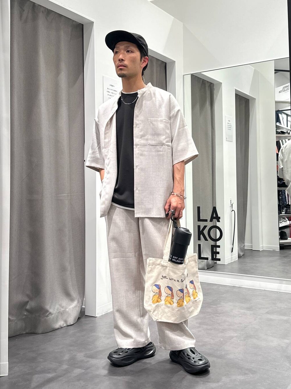 ブラック系のサンダル、ホワイト系のシャツ/ブラウス、その他のエコバッグ/サブバッグを着用したメンズの春コーディネートの5枚目の写真