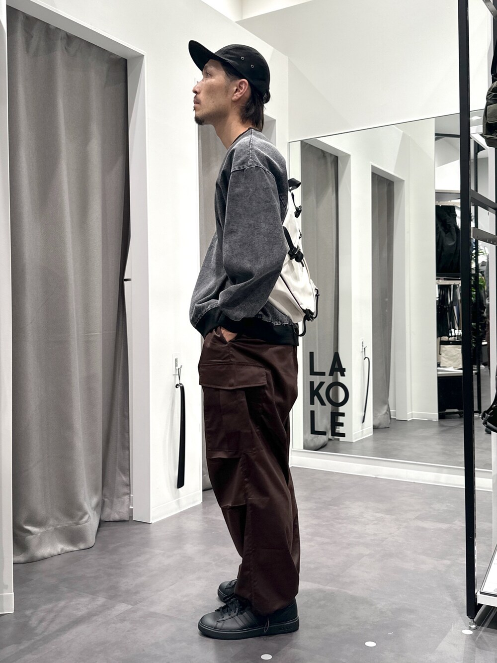 ブラック系のスニーカー、ブラウン系のカーゴパンツ、ブラック系のTシャツ/カットソーを着用したメンズの秋コーディネートの3枚目の写真