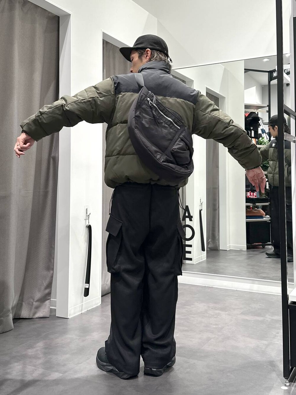 ブラック系のスニーカー、グリーン系のブルゾン、グレー系のスウェットを着用したメンズの冬コーディネートの3枚目の写真